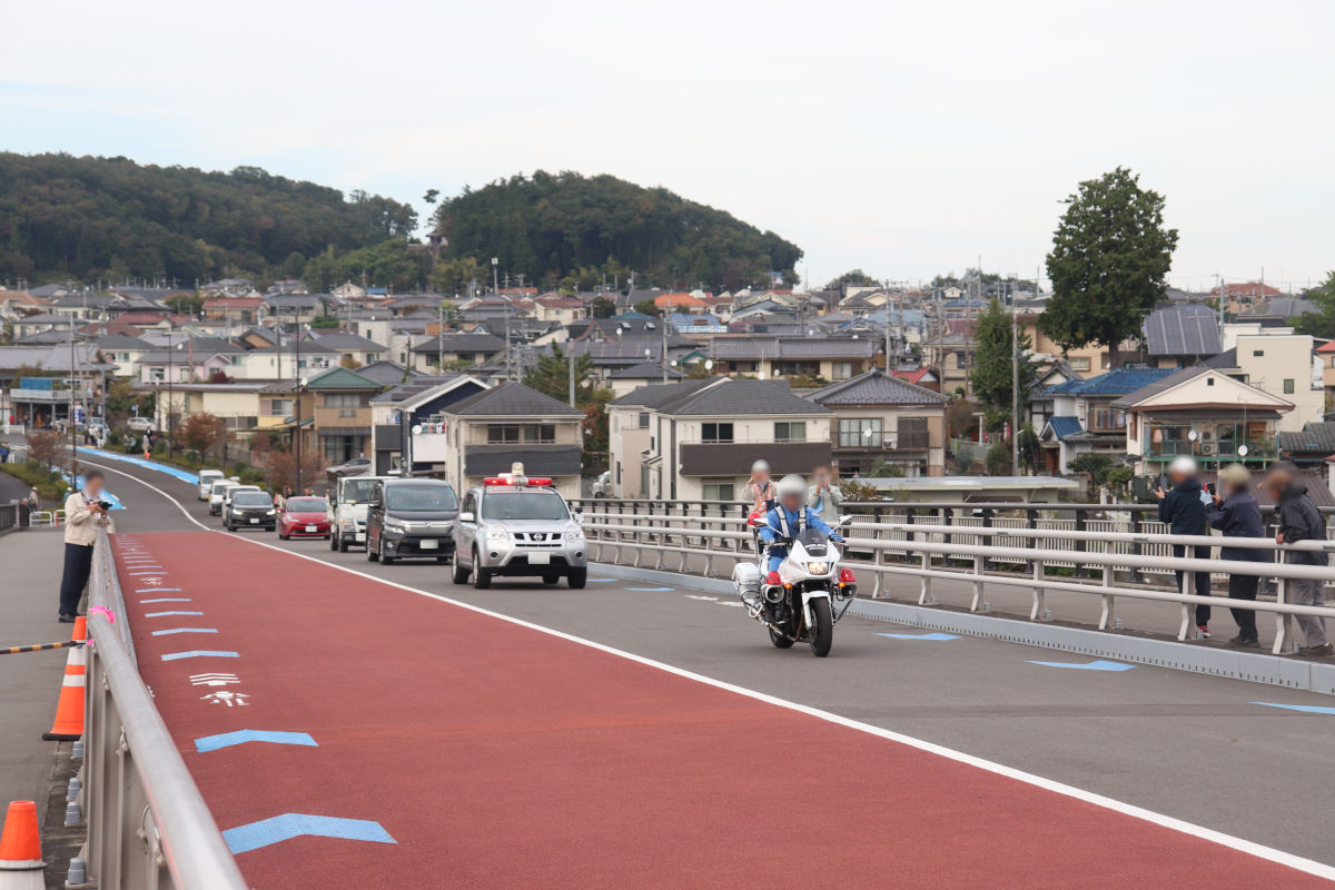 交通開放の様子。白バイと建設局の車両の先導に一般車両が続いた。